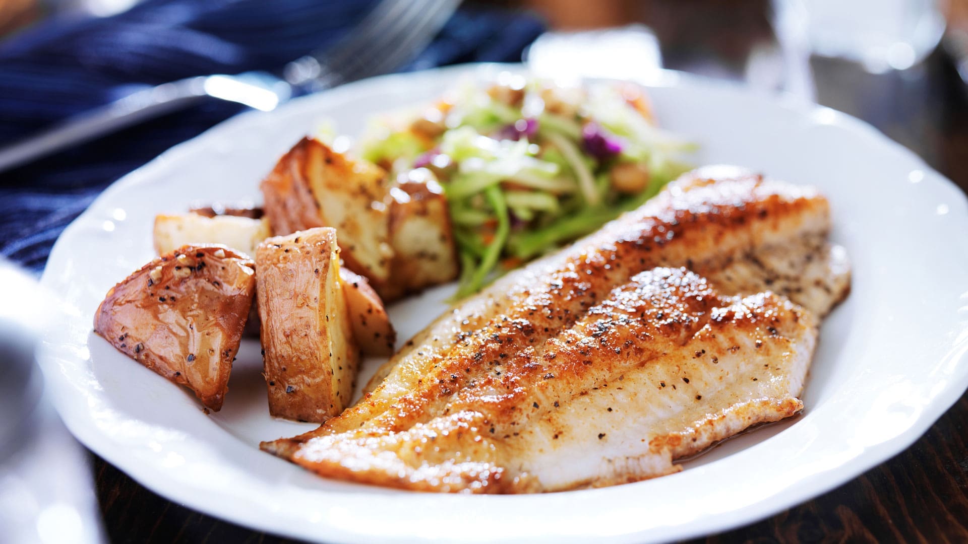 dinner plate with fish, salad, and potatoes